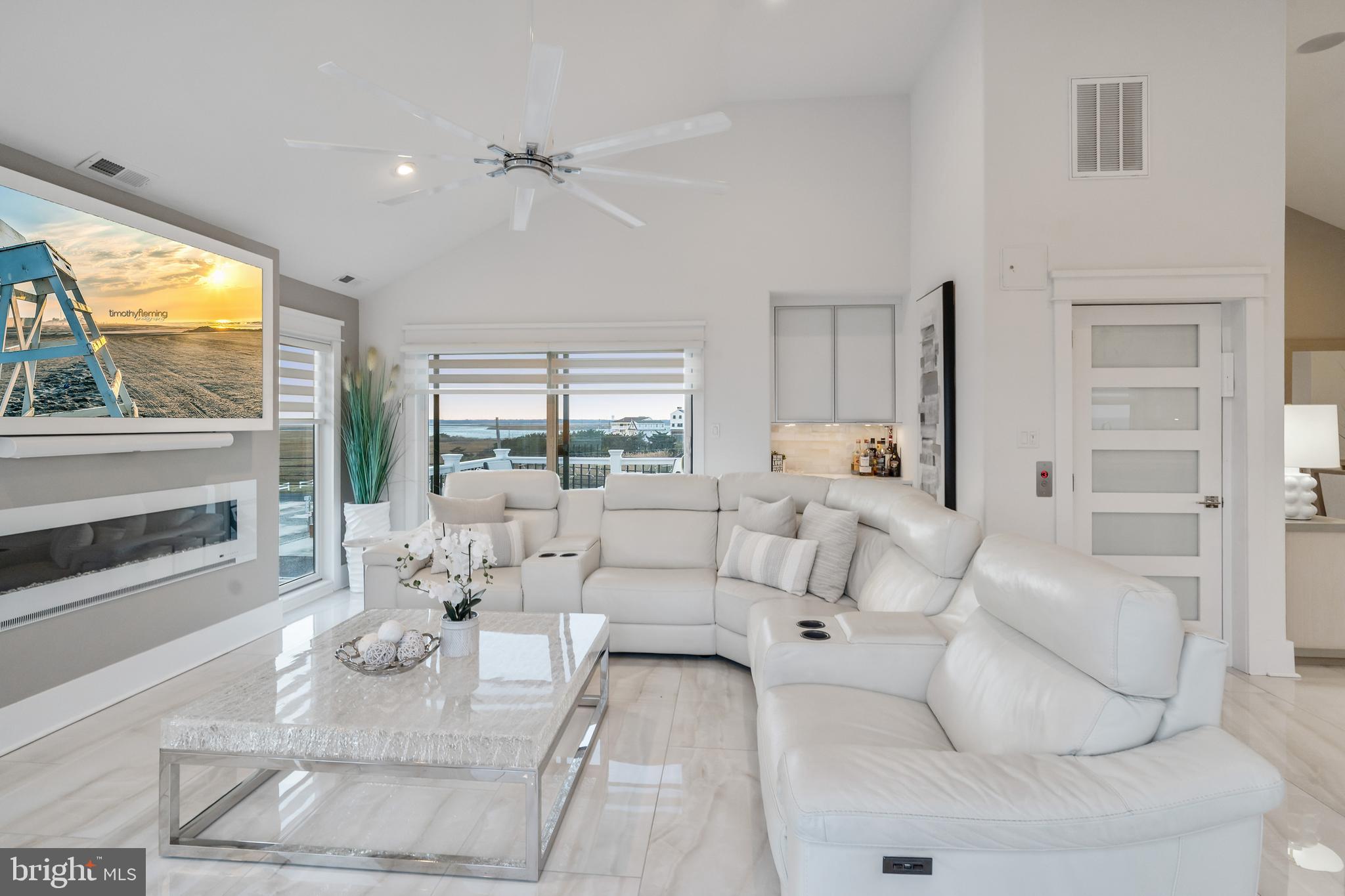 901 South Commonwealth Avenue, Unit SOUTH Strathmere, NJ 08248 - Photo 7 of 66 a living room with furniture large windows a rug and a fireplace