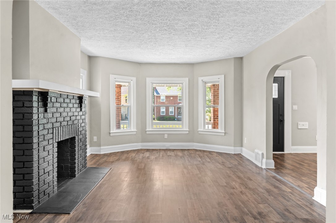 2195 Barrington Road Cleveland, OH 44118 - Photo 20 of 50 Unfurnished living room featuring a textured ceiling, wood-type flooring, and a fireplace