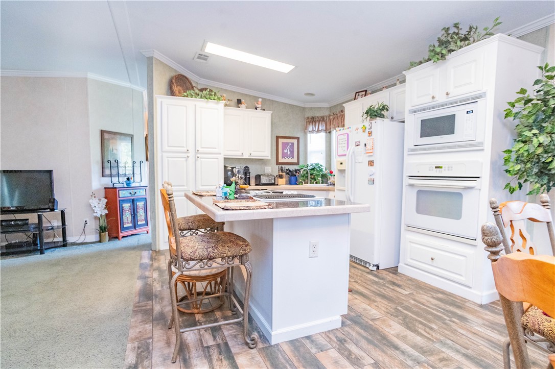 301 Valencia Street Sebastian, FL 32958 - Photo 2 of 29 a kitchen with stainless steel appliances kitchen island granite countertop a table chairs and a refrigerator