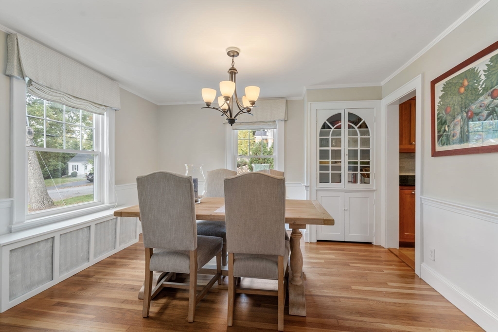 43 Bertwell Road Lexington, MA 02420 - Photo 5 of 37 a dining room with wooden floor a chandelier a wooden table and chairs
