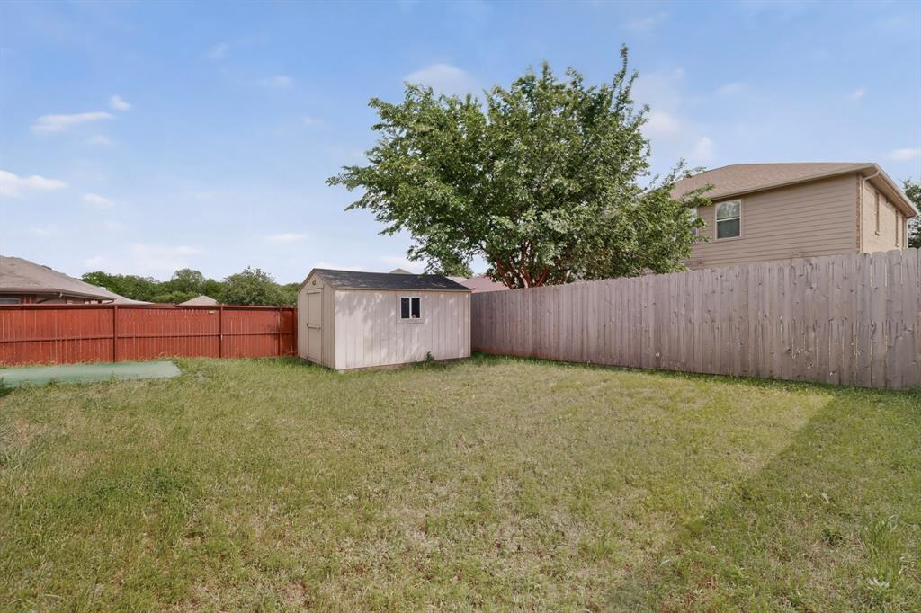 426 Harding Lane Lavon, TX 75166 - Photo 40 of 40 Spacious backyard featuring a storage shed, established tree, and privacy fencing