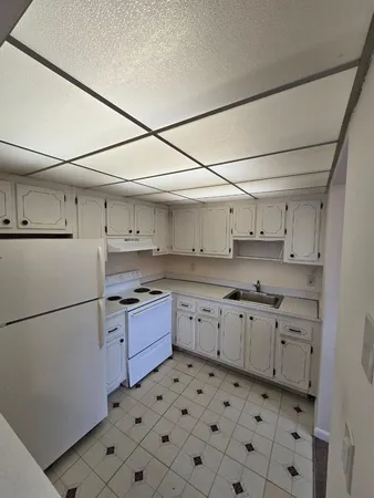 a kitchen with granite countertop appliances a sink and a refrigerator