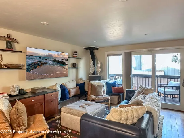 a bedroom with a balcony a bed and a large window
