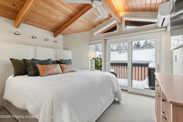 a large bed sitting in a bedroom next to a large window