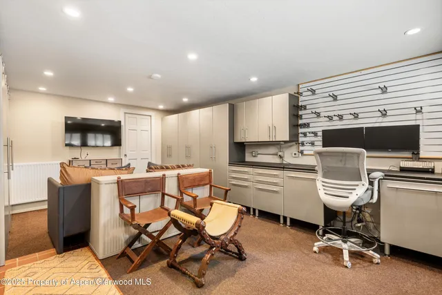 a view of a kitchen with kitchen island stainless steel appliances refrigerator stove microwave and chair