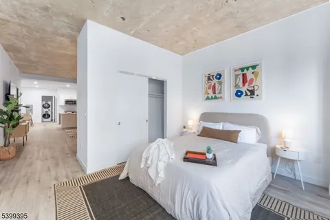 a bedroom with a bed and a painting on the wall