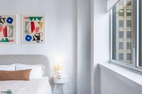 a bedroom with a bed and painting on the wall