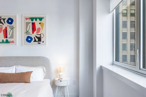 a bedroom with a bed and painting on the wall