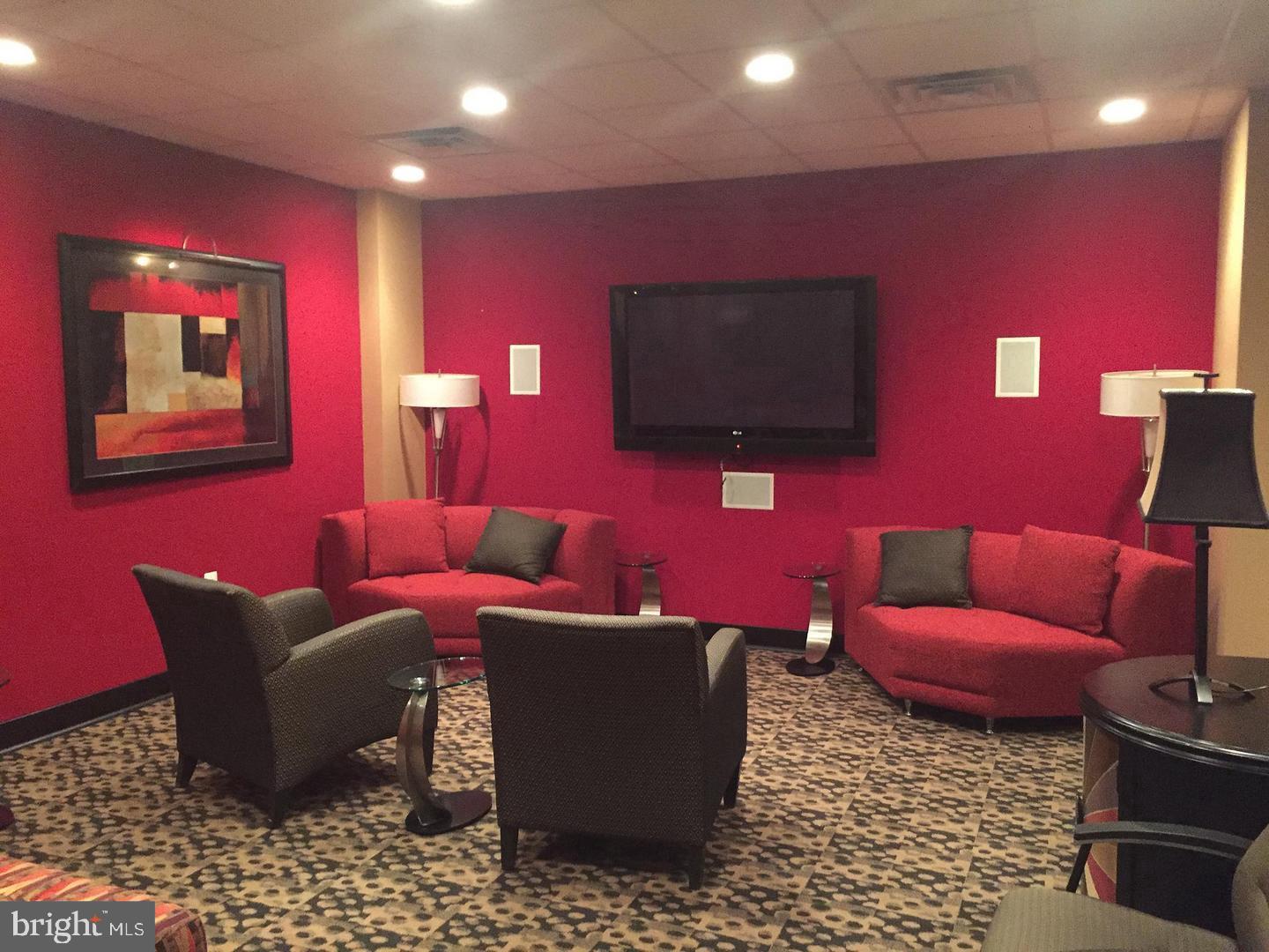 1220 Blair Mill Road, Unit 1007 Silver Spring, MD 20910 - Photo 22 of 27 a living room with furniture a red rug and a flat screen tv