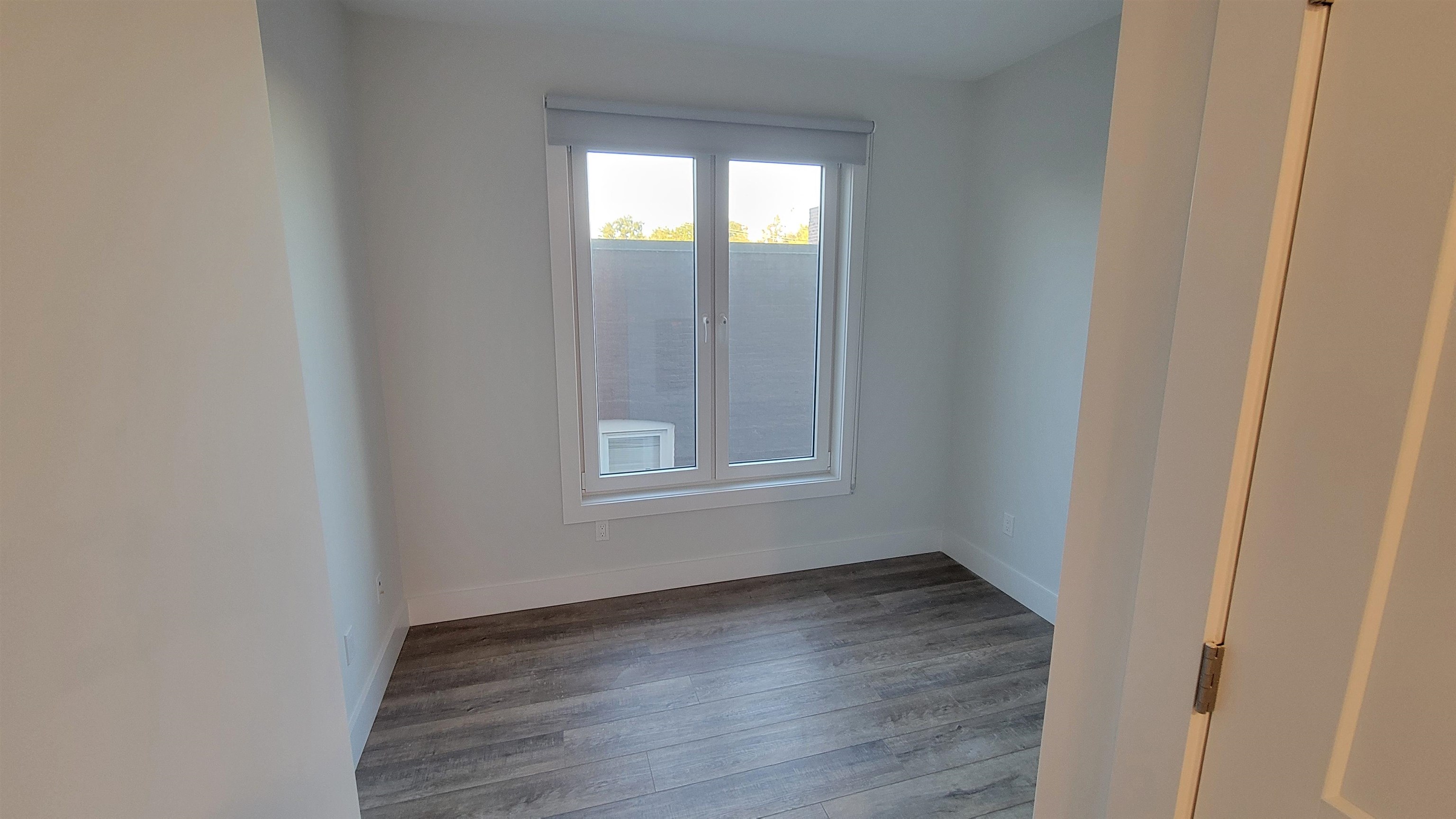 228 Park Avenue, Unit 305 East Rutherford, NJ 07073 - Photo 4 of 11 a view of an empty room with wooden floor and a window