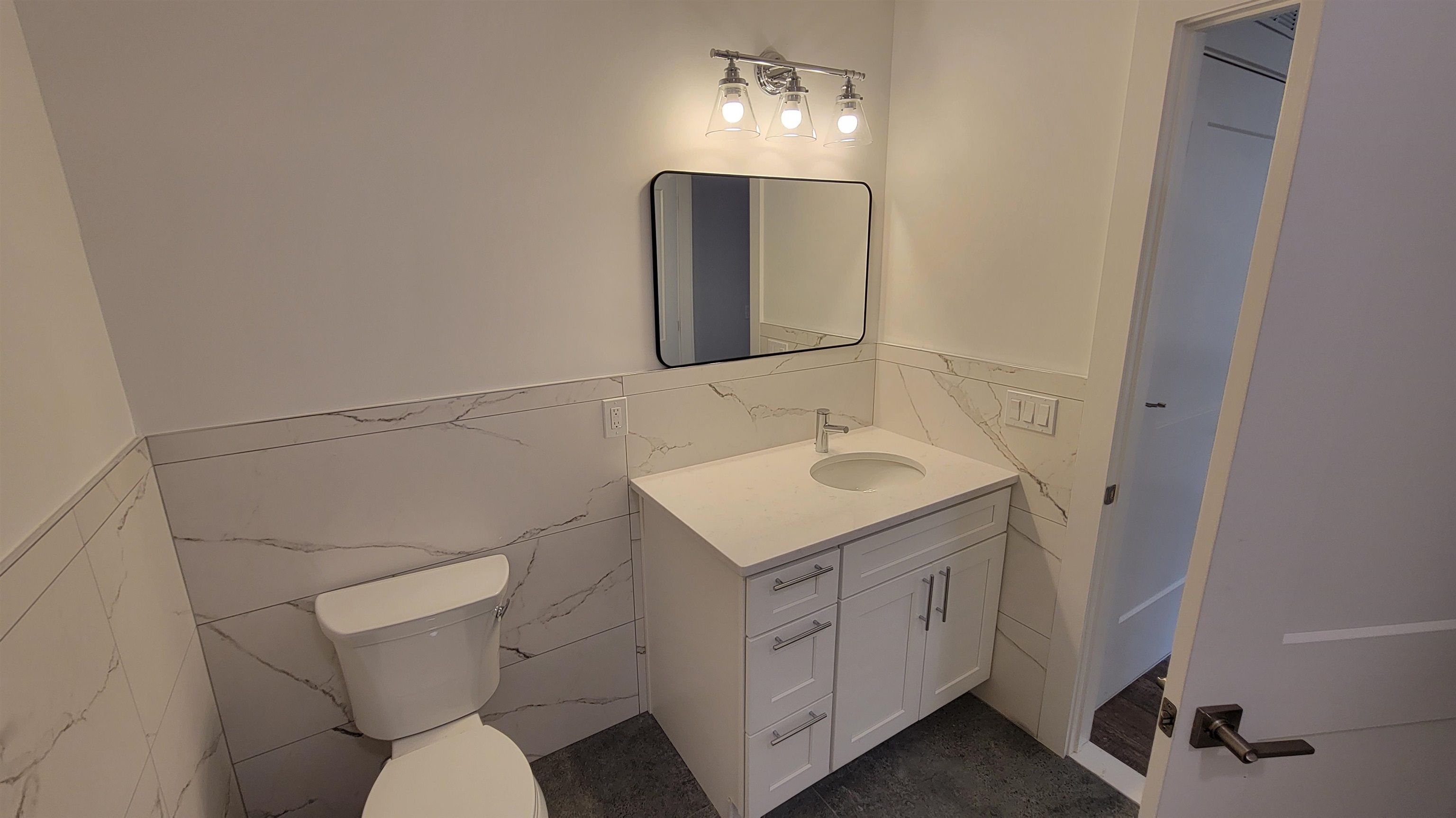 228 Park Avenue, Unit 305 East Rutherford, NJ 07073 - Photo 5 of 11 a bathroom with a sink toilet vanity and mirror
