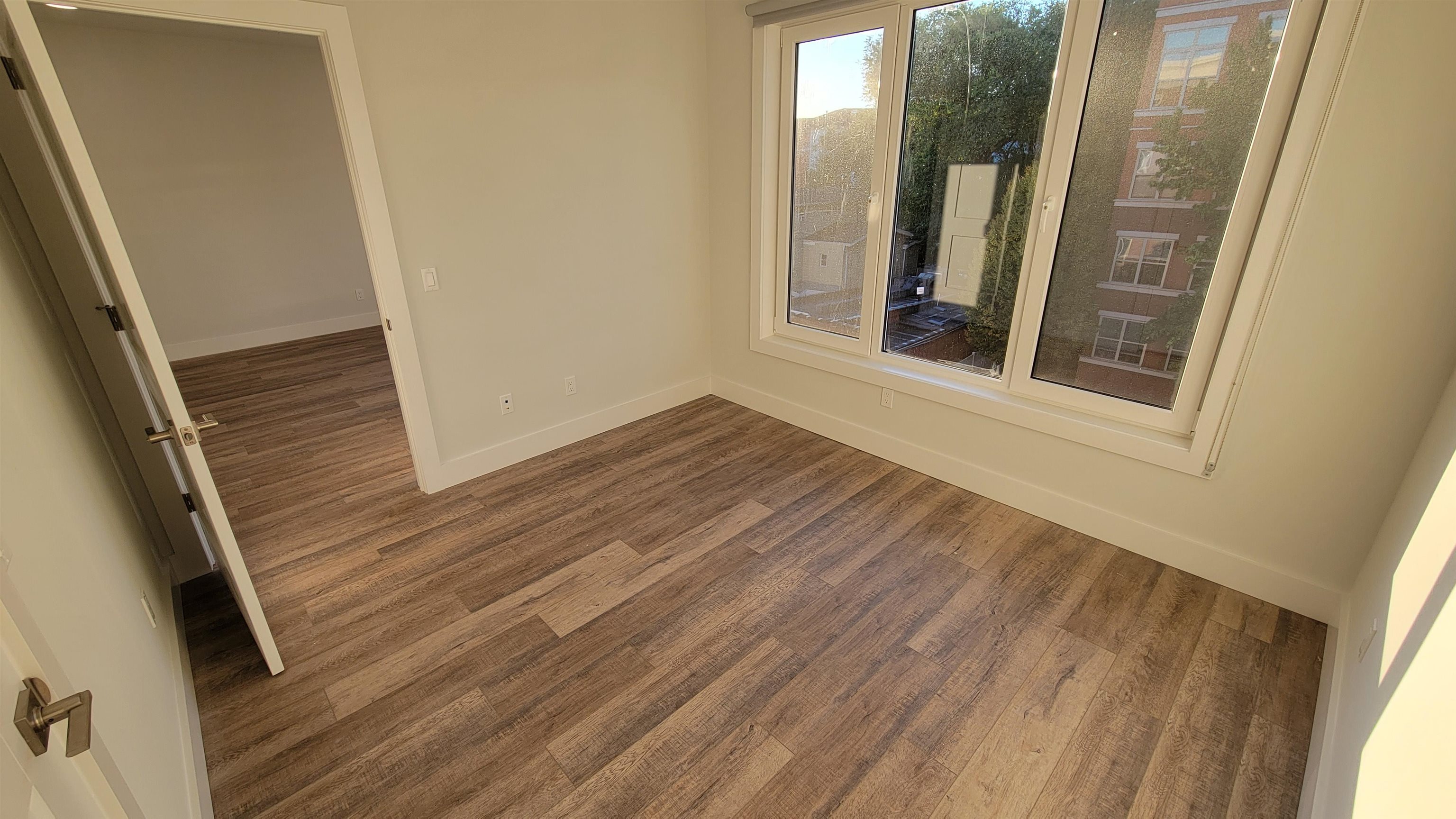 228 Park Avenue, Unit 305 East Rutherford, NJ 07073 - Photo 8 of 11 a view of an empty room with wooden floor and a window
