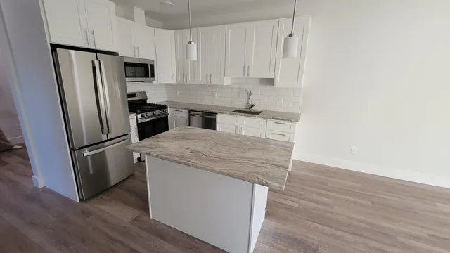 a kitchen with a refrigerator sink and cabinets