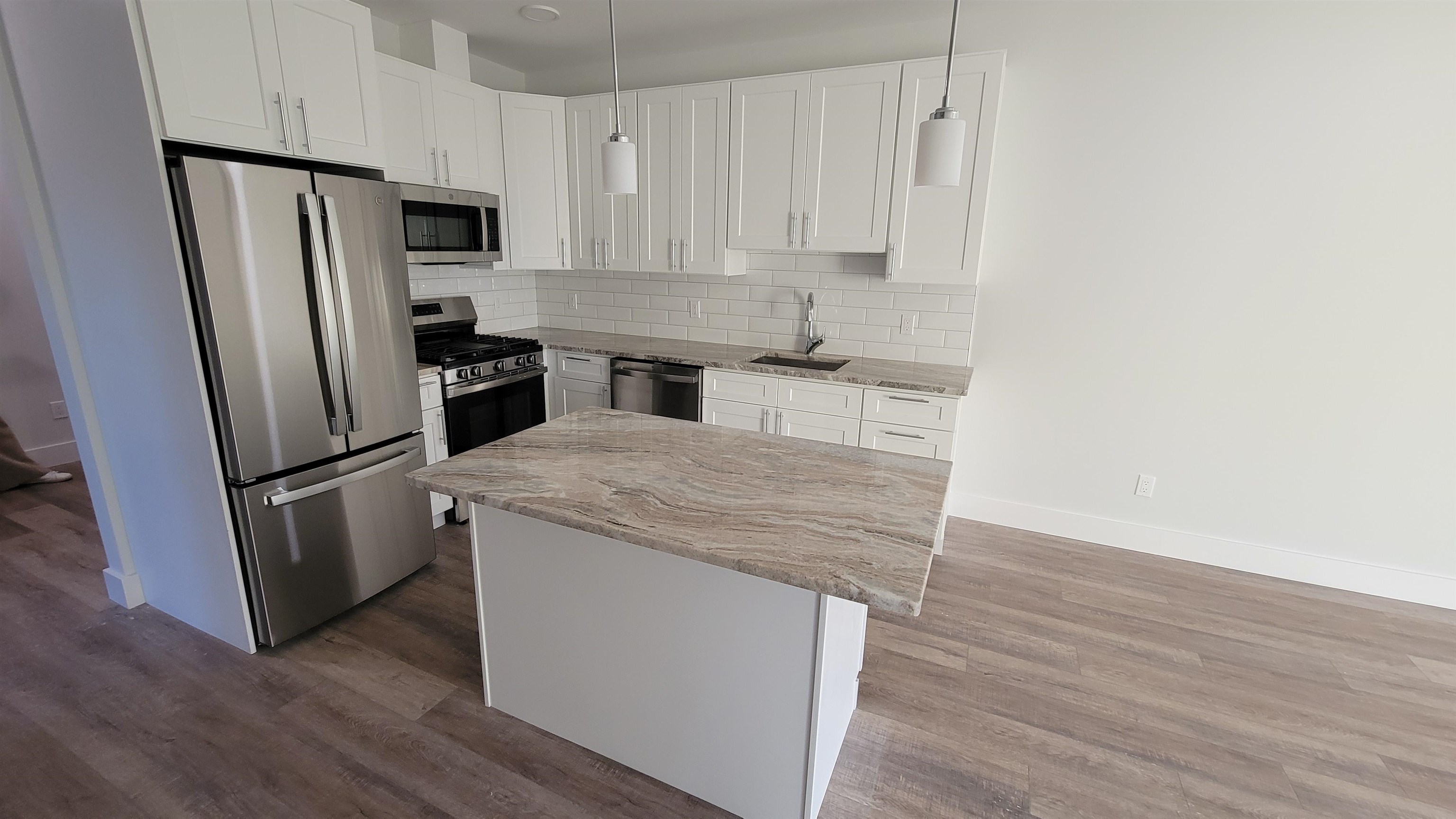 228 Park Avenue, Unit 305 East Rutherford, NJ 07073 - Photo 9 of 11 a kitchen with a refrigerator sink and cabinets