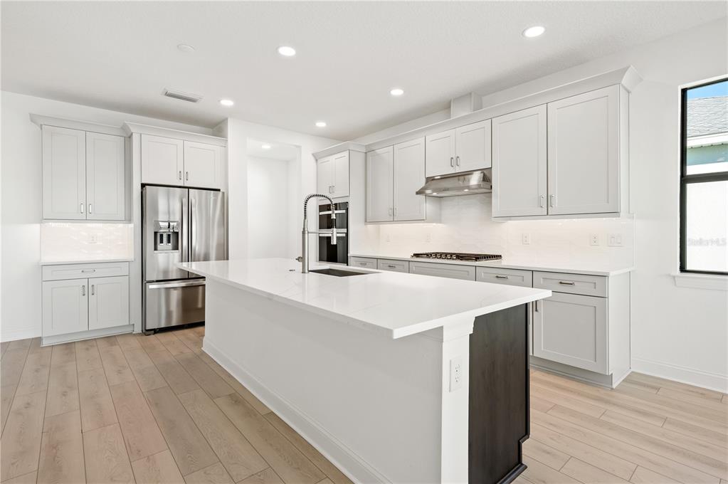 5830 Freestone Circle Apollo Beach, FL 33572 - Photo 9 of 34 a kitchen with stainless steel appliances a sink stove and refrigerator