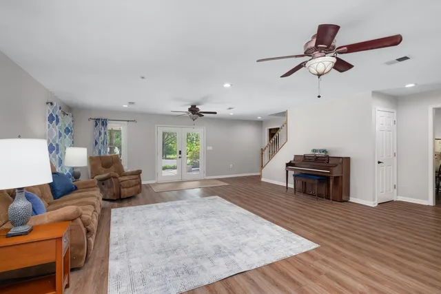 a living room with furniture and a wooden floor