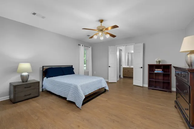 a spacious bedroom with a bed and a chandelier