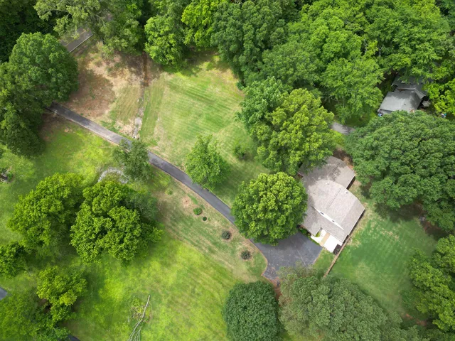an aerial view of residential houses with outdoor space and trees