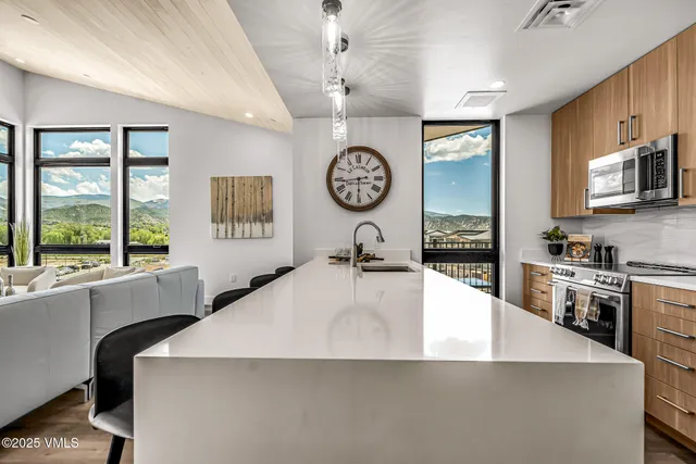 a large kitchen with stainless steel appliances a large counter top