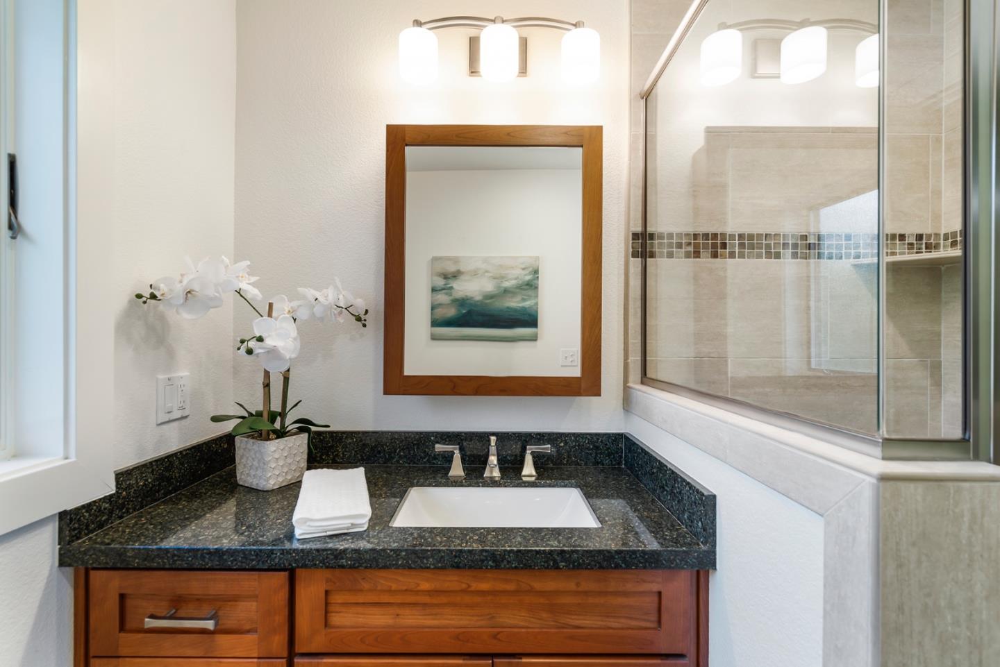 1975 Cordilleras Road Redwood City, CA 94062 - Photo 24 of 39 a bathroom with a granite countertop sink a mirror and a shower