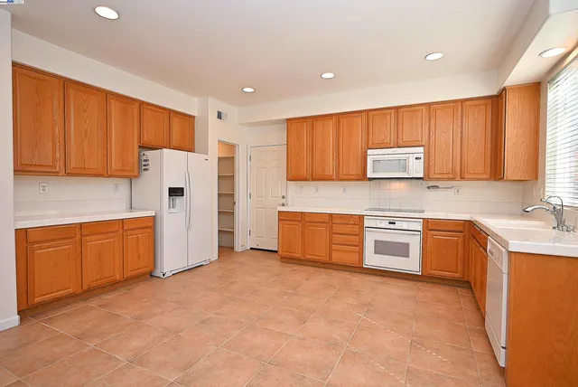 a kitchen with stainless steel appliances granite countertop a refrigerator sink and stove