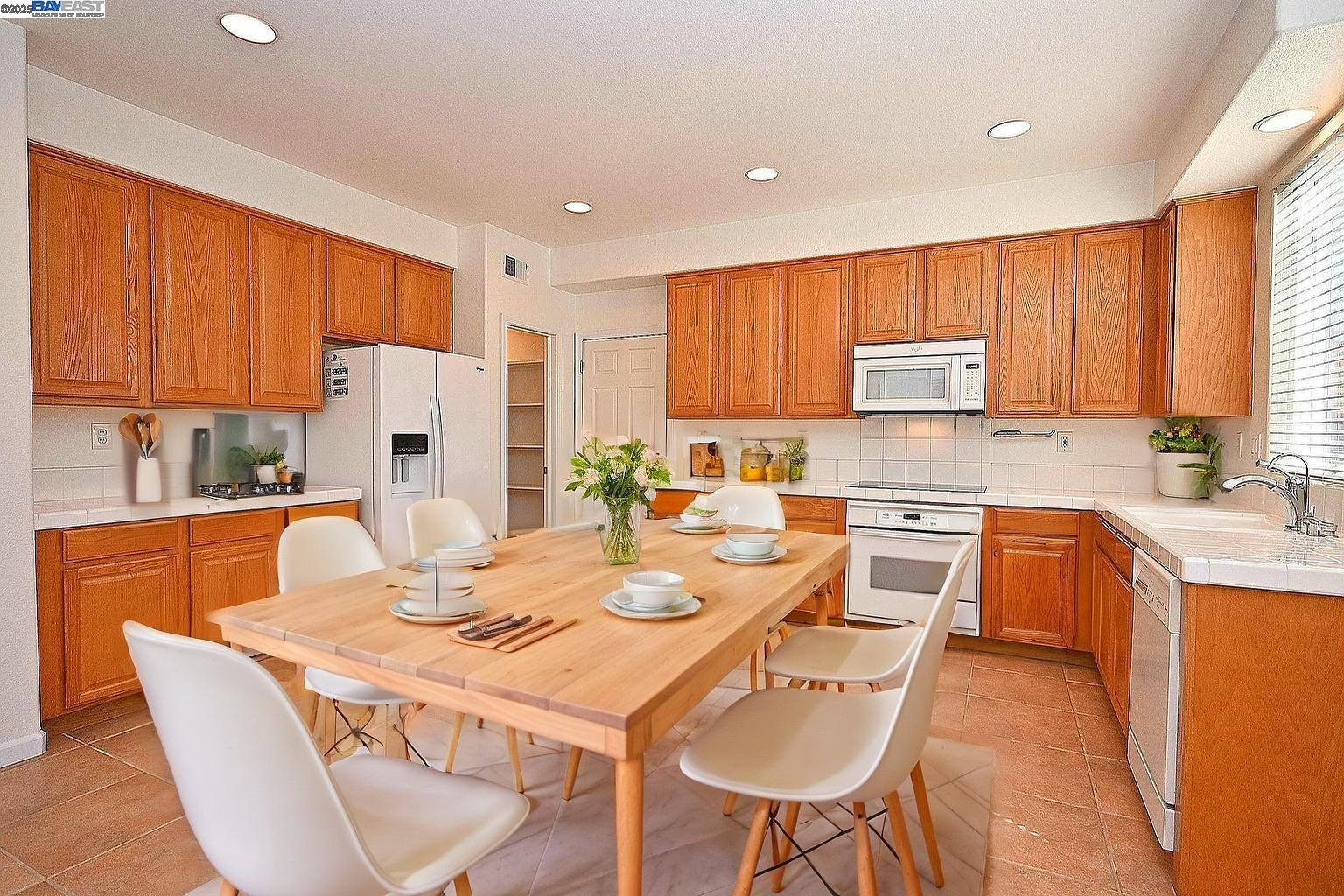 4189 Tessa Place Pleasanton, CA 94566 - Photo 15 of 41 a kitchen with a table chairs stove and refrigerator
