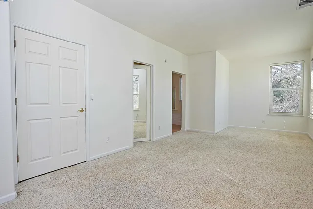 an empty room with windows and closet