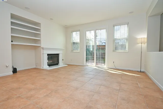 a view of empty room with a fireplace and fan