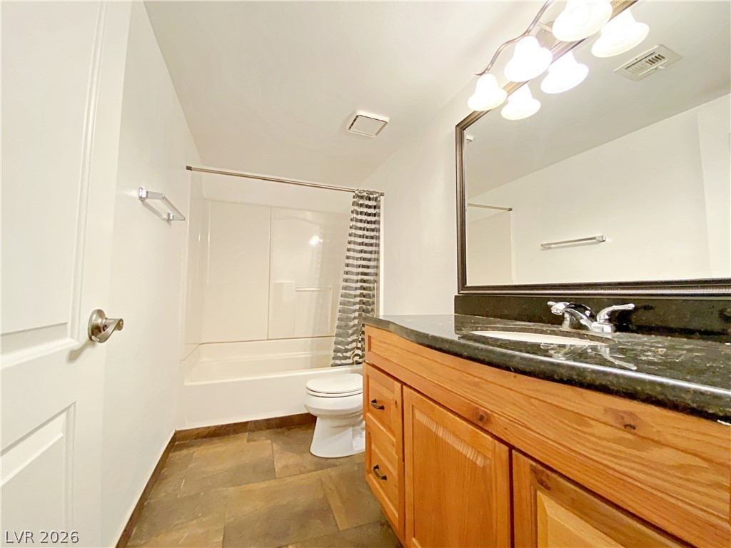 3145 East Flamingo Road, Unit 1128 Las Vegas, NV 89121 - Photo 8 of 19 A well-appointed bathroom features a sturdy vanity with a stone countertop and a practical shower-tub combination.