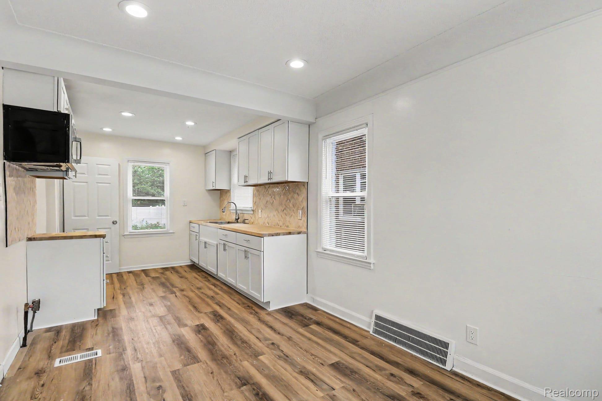 16682 Robson Street Detroit, MI 48235 - Photo 12 of 19 Kitchen featuring wood-finish flooring, recessed lighting, white cabinetry, a built-in microwave, and a wood-finish countertop