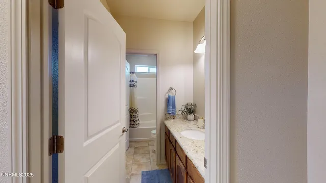a en suite bathroom with a granite countertop sink and a mirror