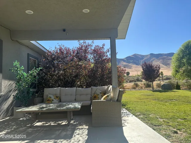a view of a couches in the patio with a small yard
