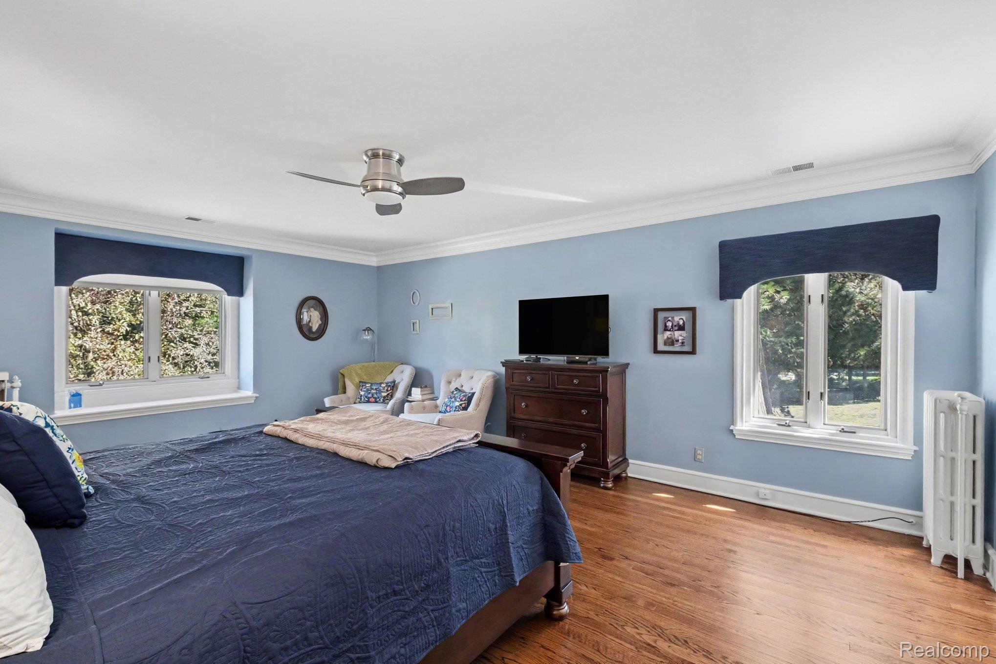 2030 Hampden Road Flint, MI 48503 - Photo 18 of 34 Hardwood flooring, crown molding, double windows, ceiling fan with light, and a built-in radiator