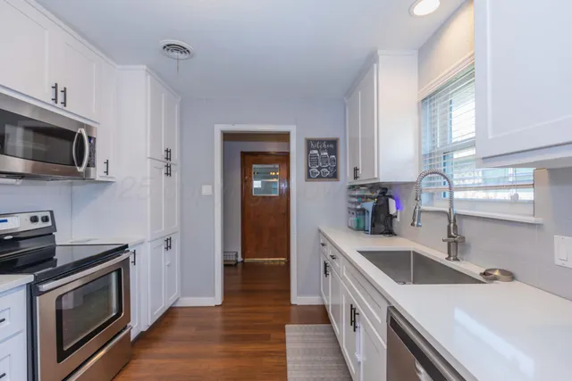 a kitchen with a sink stove top oven and refrigerator