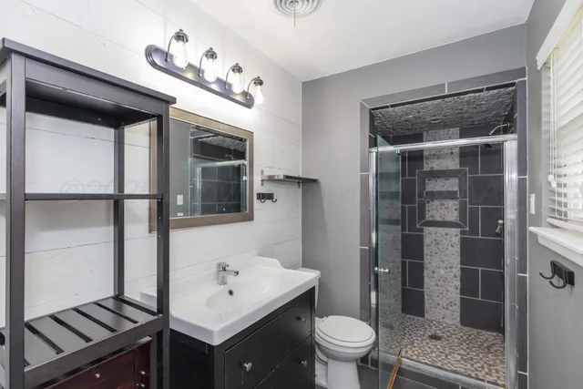 a bathroom with a sink a toilet and shower