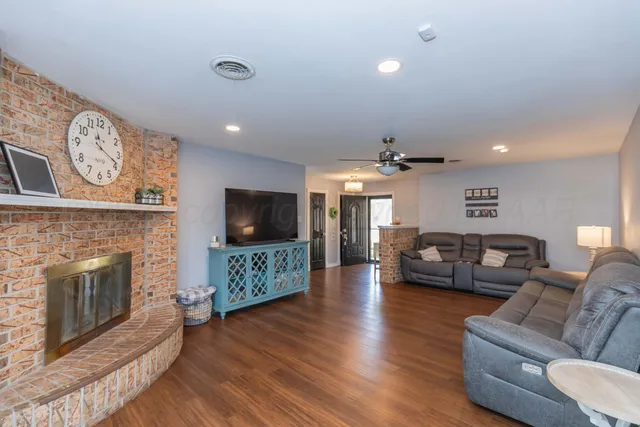 a living room with furniture a flat screen tv and a fireplace