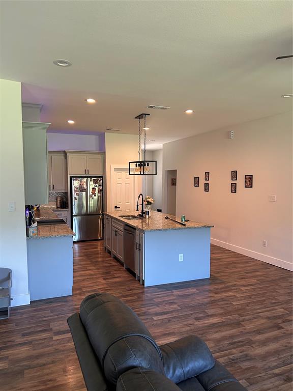 2631 Fish Tank Road Corsicana, TX 75110 - Photo 13 of 31 a kitchen with stainless steel appliances granite countertop a living room and couches with wooden floor