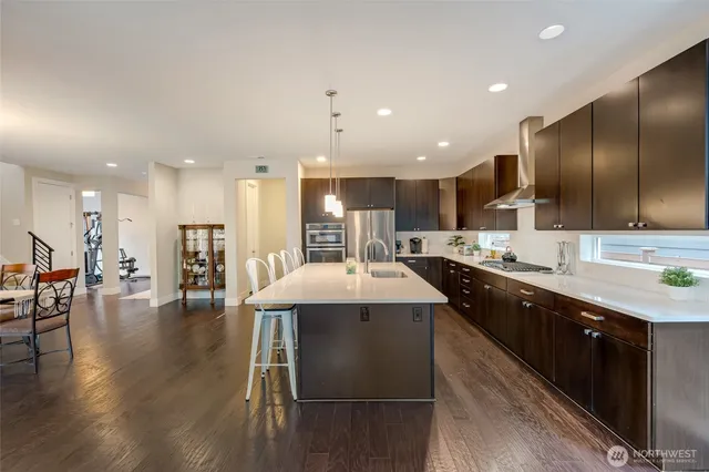 a large kitchen with stainless steel appliances kitchen island granite countertop a large kitchen island and a sink