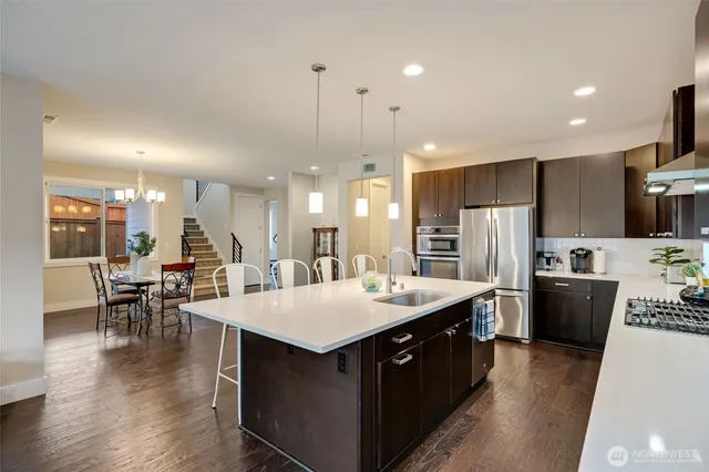a large kitchen with kitchen island a sink a counter space and stainless steel appliances
