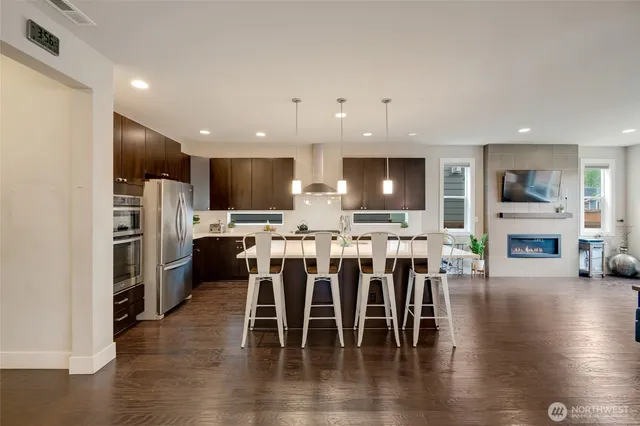 a view of kitchen with refrigerator stove dining table and chairs