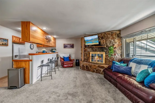 a living room with furniture a fireplace and a large window
