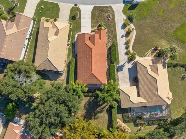 an aerial view of residential houses with outdoor space and parking