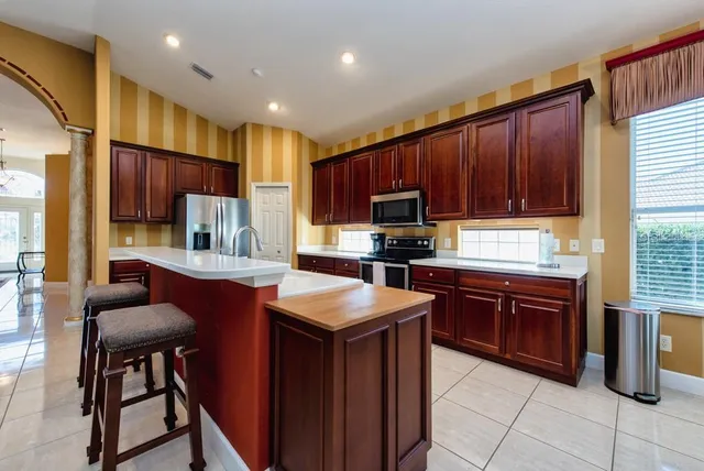 a kitchen with kitchen island granite countertop wooden cabinets a center island and stainless steel appliances