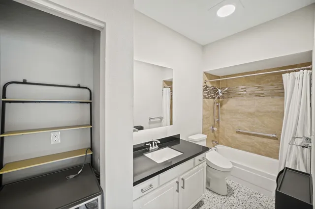 a bathroom with a granite countertop sink a toilet and bathtub