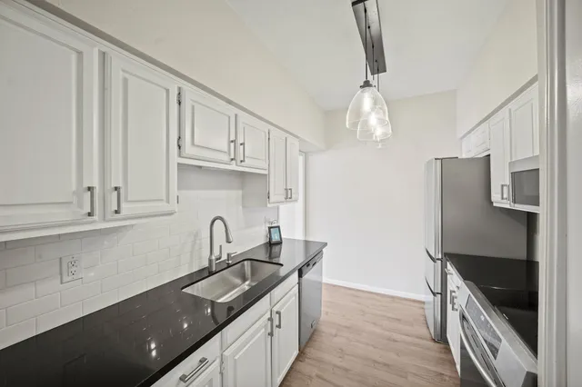 a kitchen with stainless steel appliances a sink stove and cabinets