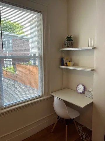 a view of a room with a window and wooden floor