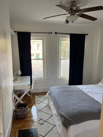a bedroom with a bed and wooden floor
