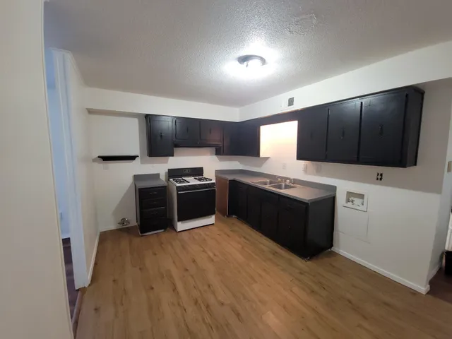 a kitchen with stainless steel appliances kitchen island granite countertop a stove a sink and a microwave