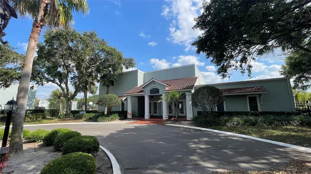 a view of a white house with a large tree