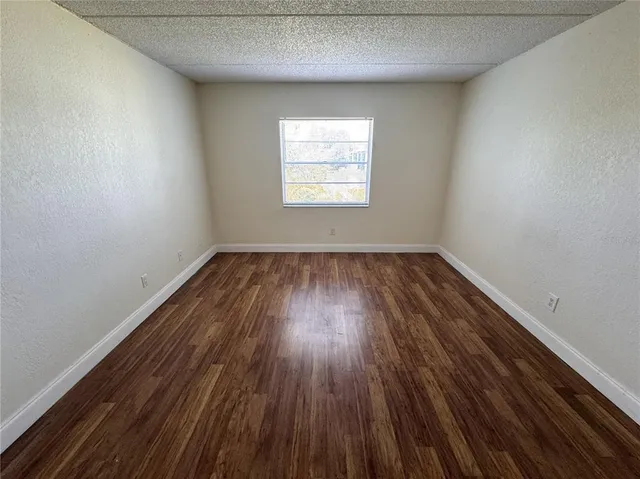 a view of a room that has wooden floor and window in it